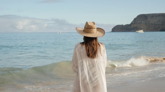 海滩上戴帽子的女人