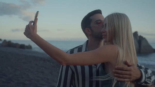 Una pareja se toma un selfie en la playa.