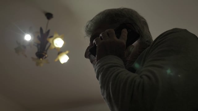 Vista inferior de un anciano hablando por un teléfono móvil