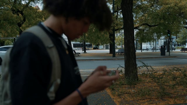 Una foto borrosa de un chico con un teléfono inteligente.