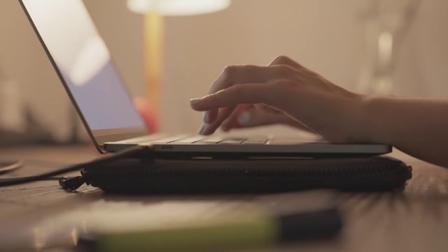 Una niña escribiendo en una computadora portátil