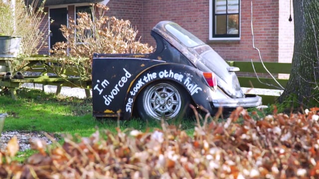Destroyed car with funny, painted text