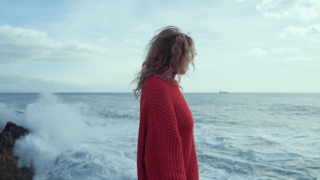 Una mujer joven observa un mar violento
