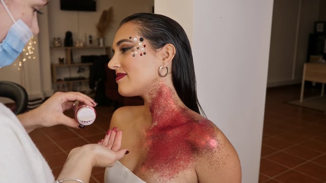 Makeup artist applies glitter 