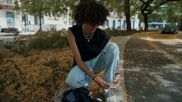 A young man ties his shoelaces