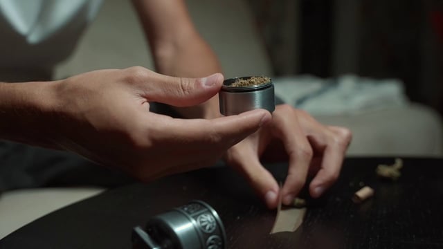 A man preparing his marijuana joint for smoking