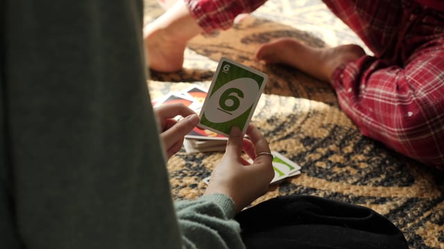 A daughter wins a game of UNO against her mom