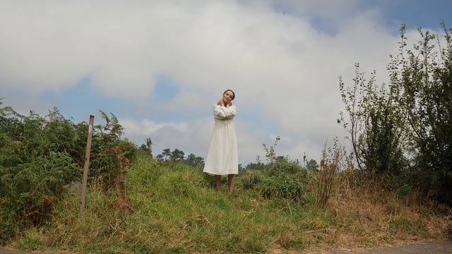 Woman in white standing in a field