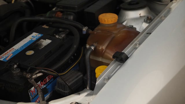 Pouring liquid into car washer fluid reservoir