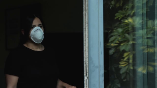 Woman wearing a mask near balcony 