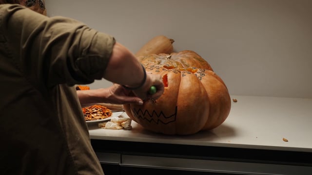 Carving a nose on a pumpkin