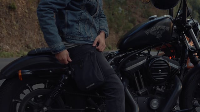 Un motociclista está sacando una tarjeta de crédito de su bolso.