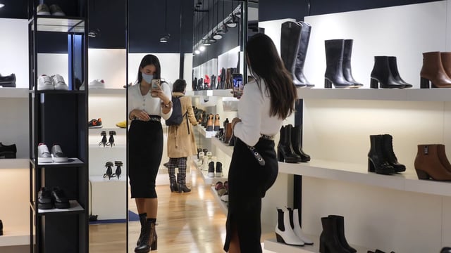 Woman looking at boots in the mirror