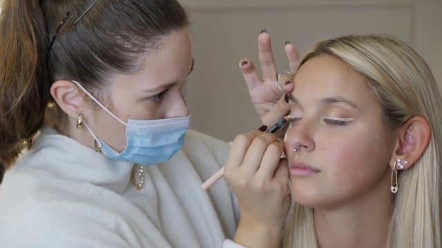 Makeup artist applies eyeliner