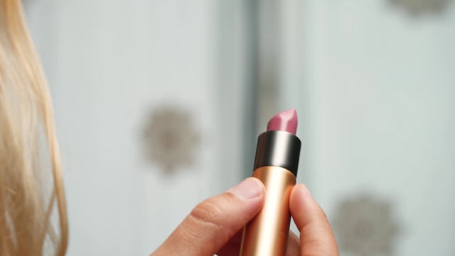 Applying pink lipstick