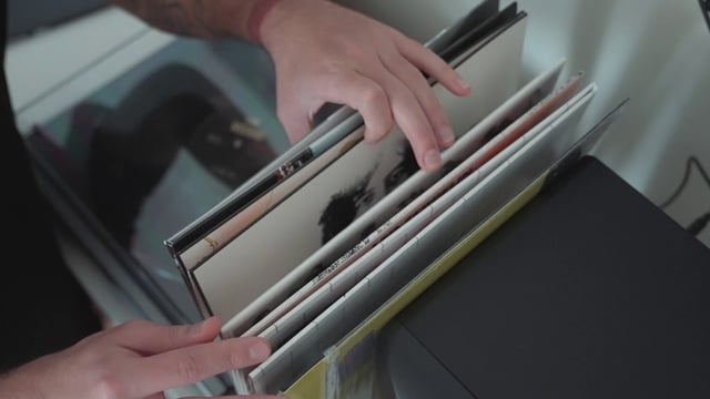 Hands leafing through vinyl disc cases