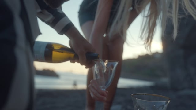 Verter vino en vasos en la playa