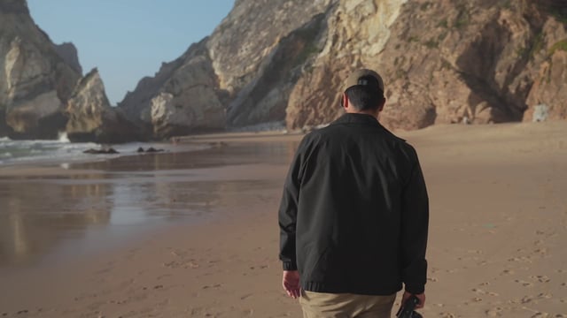 一名男子在数码相机上拍摄海滩