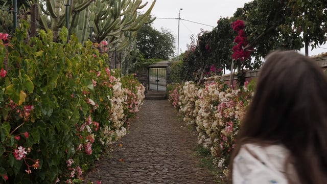 Mujer corriendo cerca de un jardín de flores
