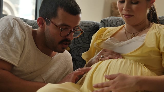Father caressing woman's pregnant belly