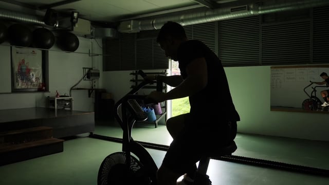 Deportista está entrenando en la bicicleta estática