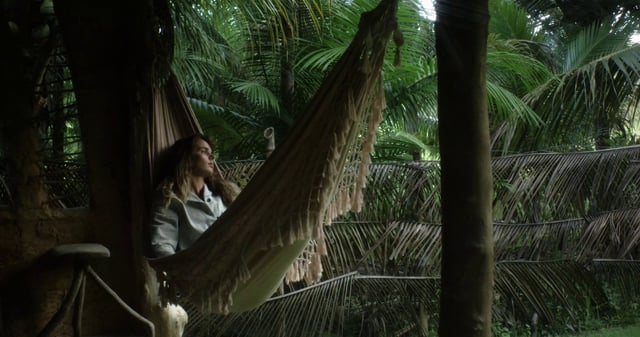 Una niña acostada en una hamaca en la jungla