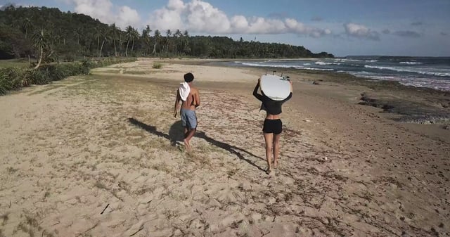 Couple walking towards the ocean