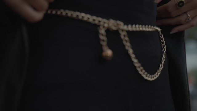 A view of the intricate details of a belt and jewelry
