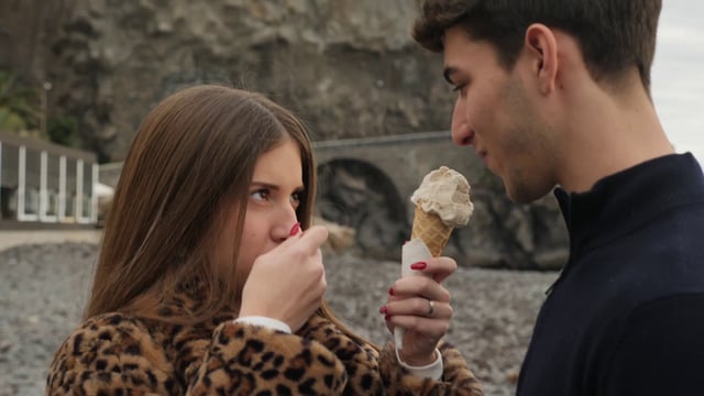 Una chica le da a un chico que pruebe un helado