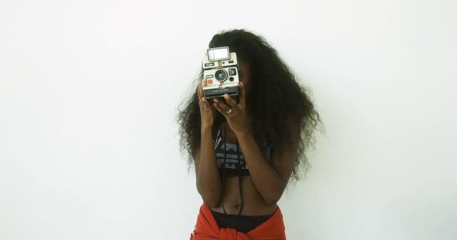 Una niña toma fotos con una cámara Polaroid