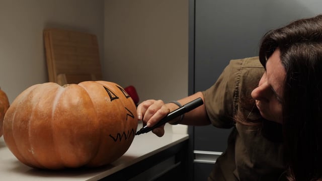 Drawing a mouth on a pumpkin
