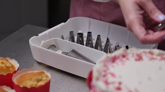 Una mujer pone sus boquillas de pastelería en una caja de plástico