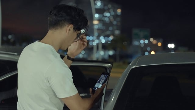Hombre asiático usa un teléfono inteligente como un espejo