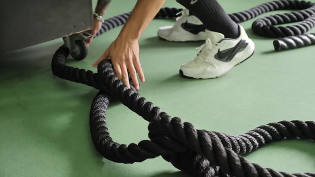 Un hombre prepara una cuerda de batalla para hacer ejercicio