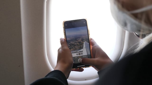 Woman taking photos from plane