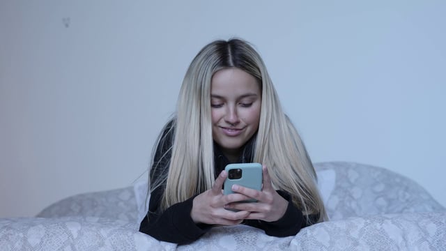 Girl using iPhone in bed - Free Stock Video Footage | Coverr