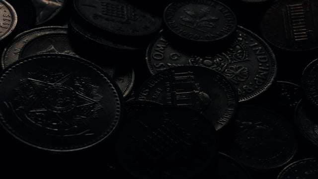 A heap of old coins illuminated by studio lighting
