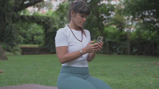 Yoga teacher typing on a smartphone