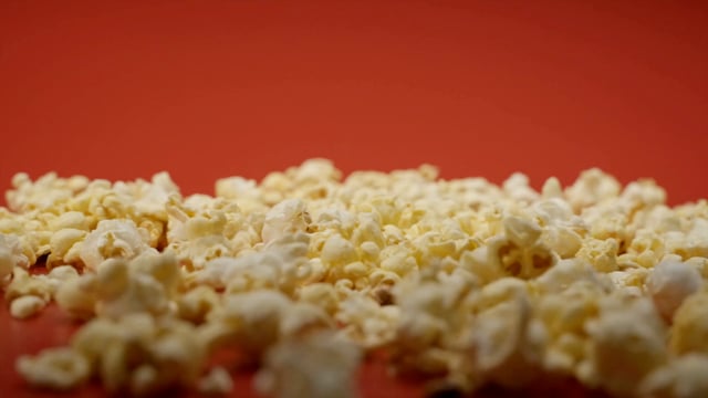 Un montón de palomitas de maíz cae sobre una mesa roja