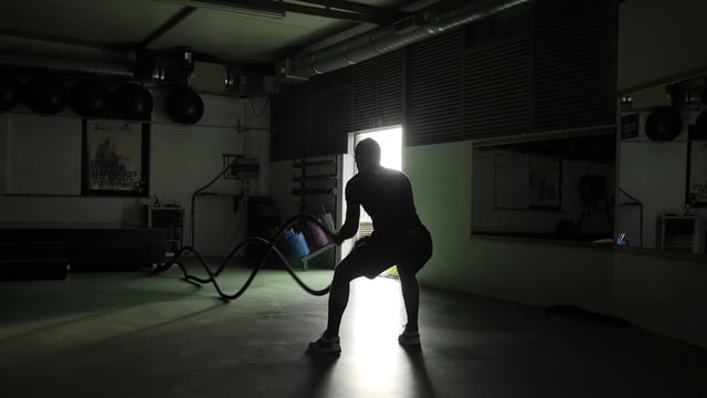 Atleta haciendo ejercicio con cuerda de batalla