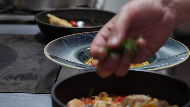 Chef agregando perejil a un plato en un restaurante