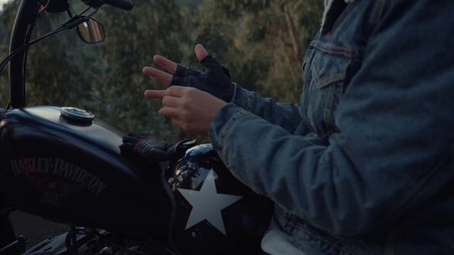 A motorcyclist taking his gloves off