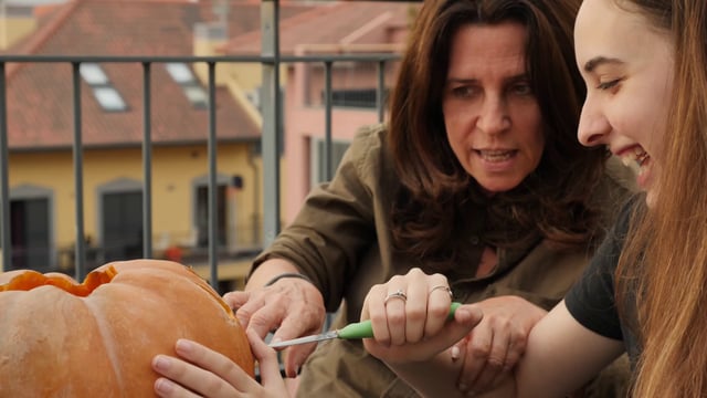 Mom and daughter carving a pumpkin
