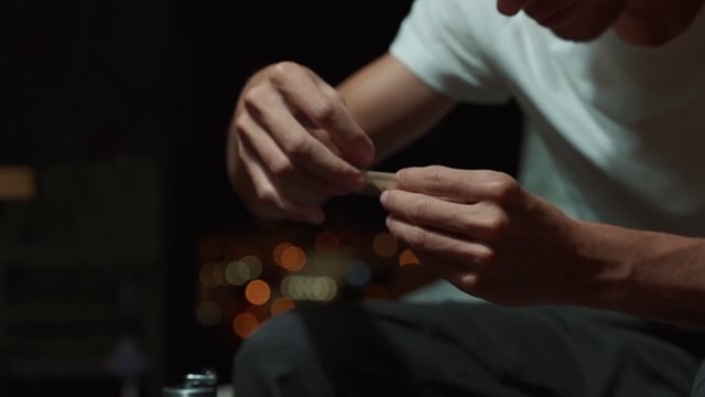 A man carefully prepares joint to smoke