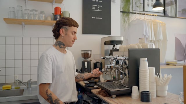 Barista Makes a Coffee Using a Coffee Machine