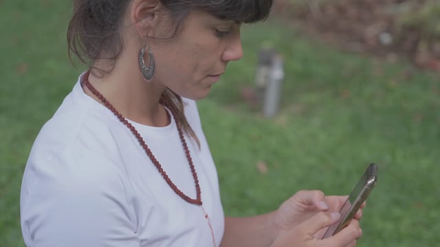 A yoga teacher types on a smartphone