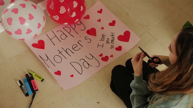 Daughter making a banner for Mother's Day