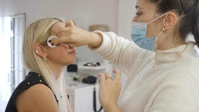 Makeup artist wipes woman's skin