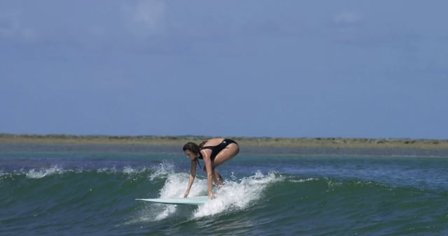 Una surfista montando una pequeña ola