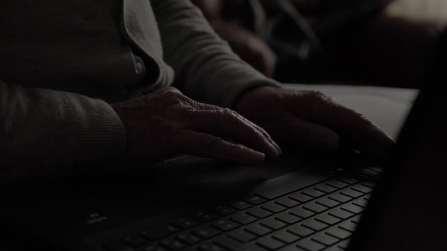Cerca de las manos de un anciano use un panel táctil en una computadora portátil